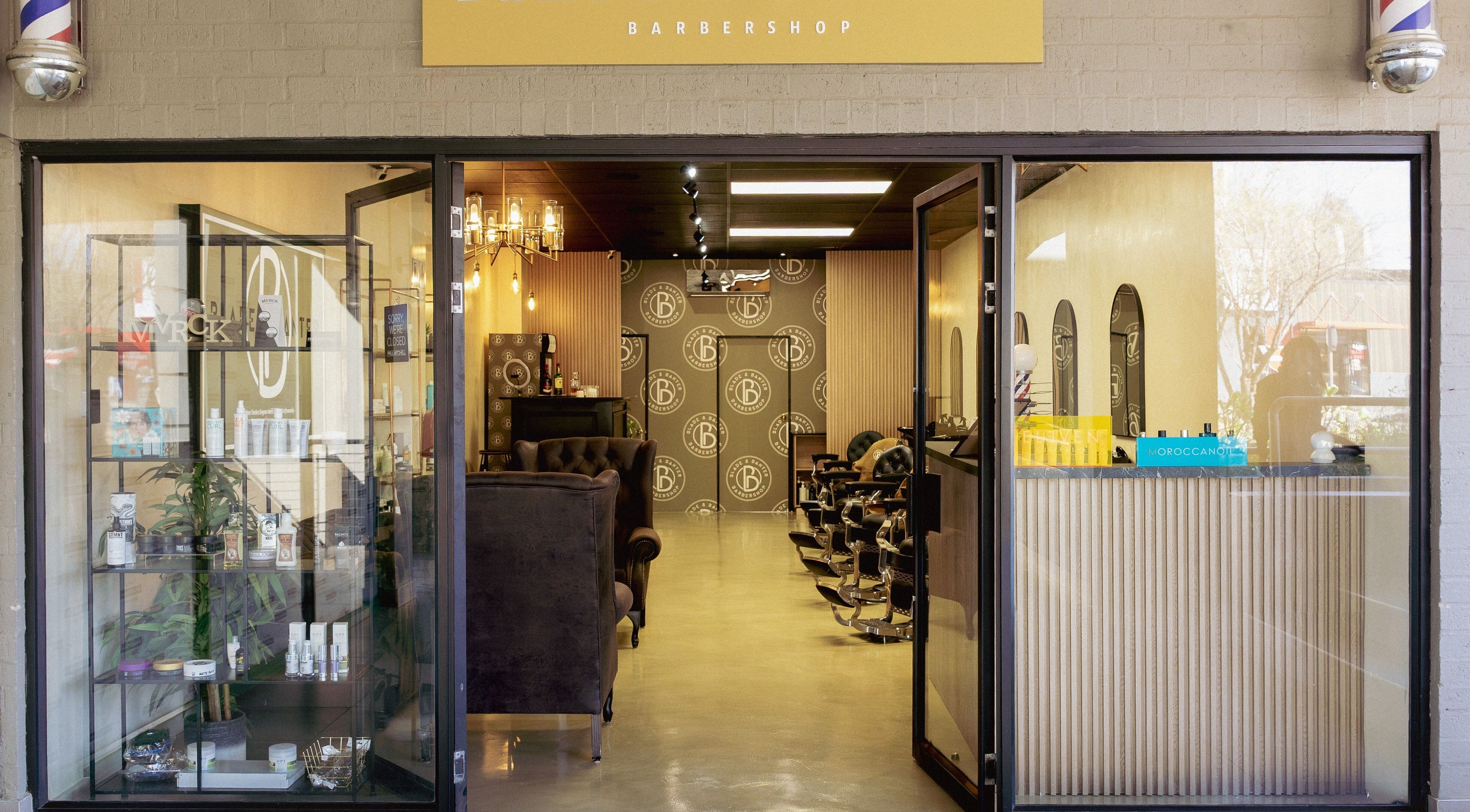 Entrance of Blade & Banter Barbershop in Midrand, Gauteng, ZA, showcasing stylish interior and barber chairs.