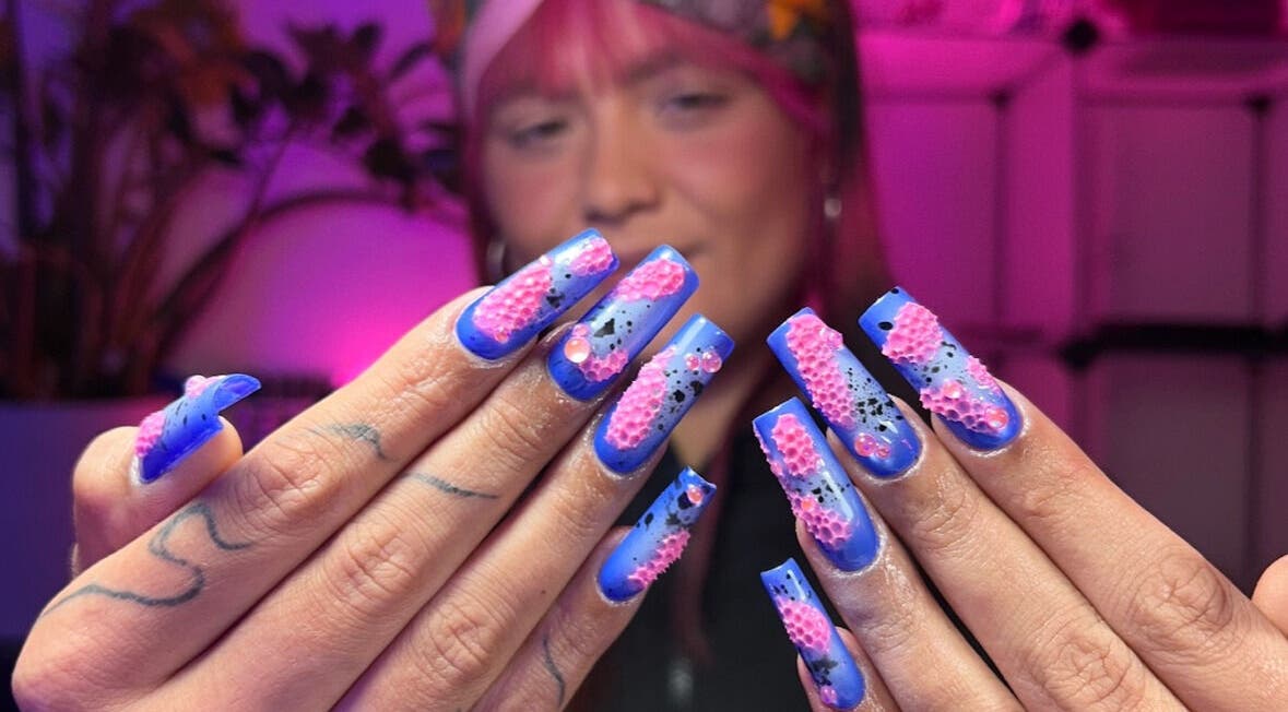 Kleurrijke nagelkunst bij Bassment Studio Rotterdam, Zuid-holland, NL, met roze en blauwe accenten.