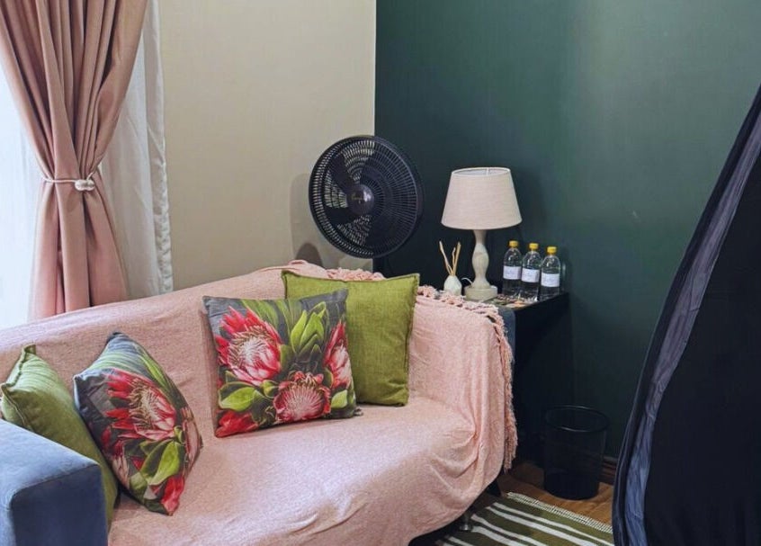 Cozy corner at Glow Tan Spray Tan Salon, Olifantsfontein, Gauteng, ZA with a plush sofa and elegant decor.