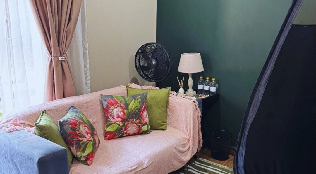 Cozy corner at Glow Tan Spray Tan Salon, Olifantsfontein, Gauteng, ZA with a plush sofa and elegant decor.