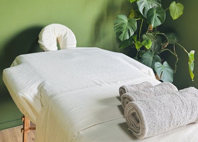 Rustige massagetafel bij Melohh Massage (for women only) in Amsterdam, Noord-Holland, NL, omlijst door groene planten.