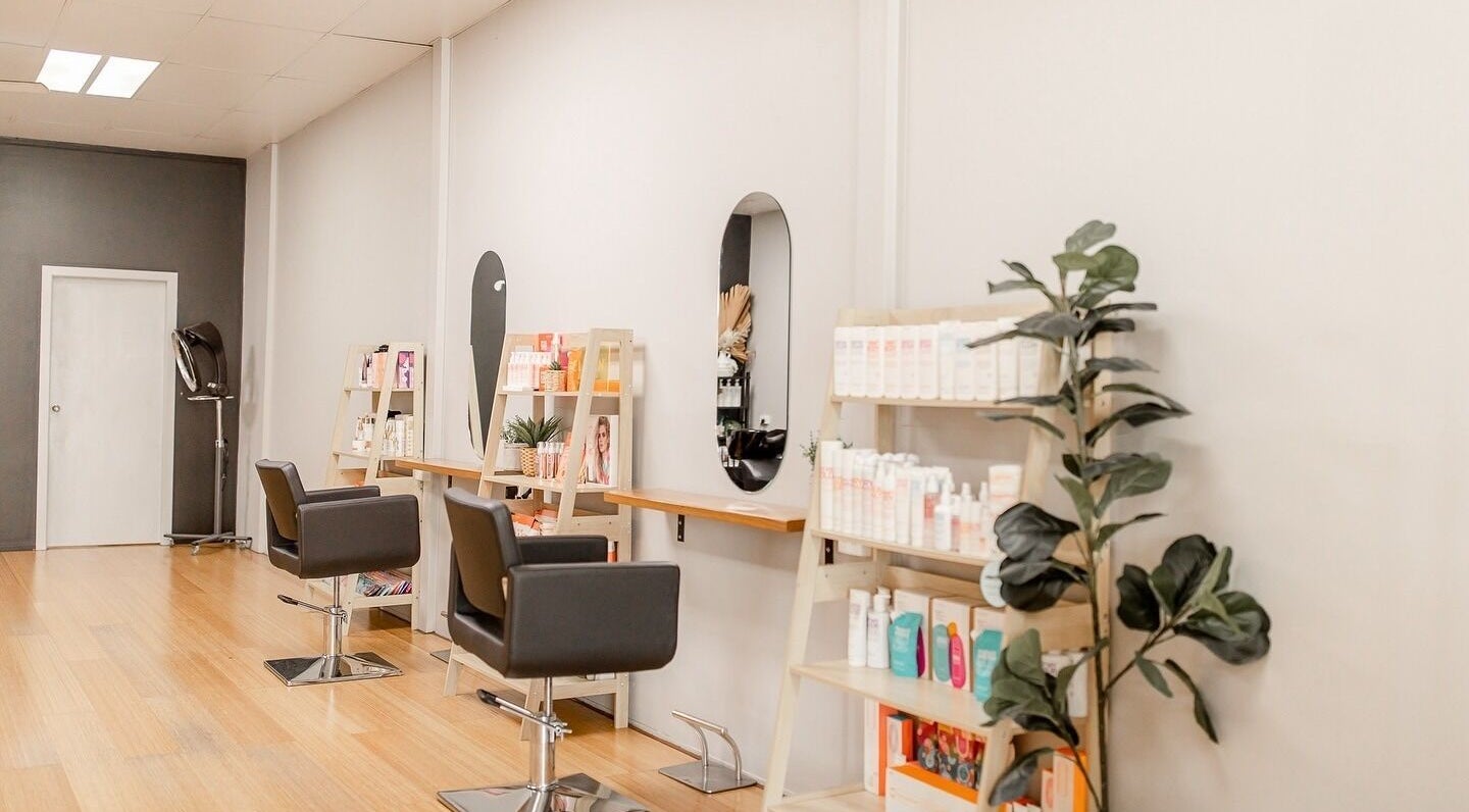 Interior of Heavenly Hair Studio Kempsey in West Kempsey, New South Wales AU with elegant chairs and product shelves.