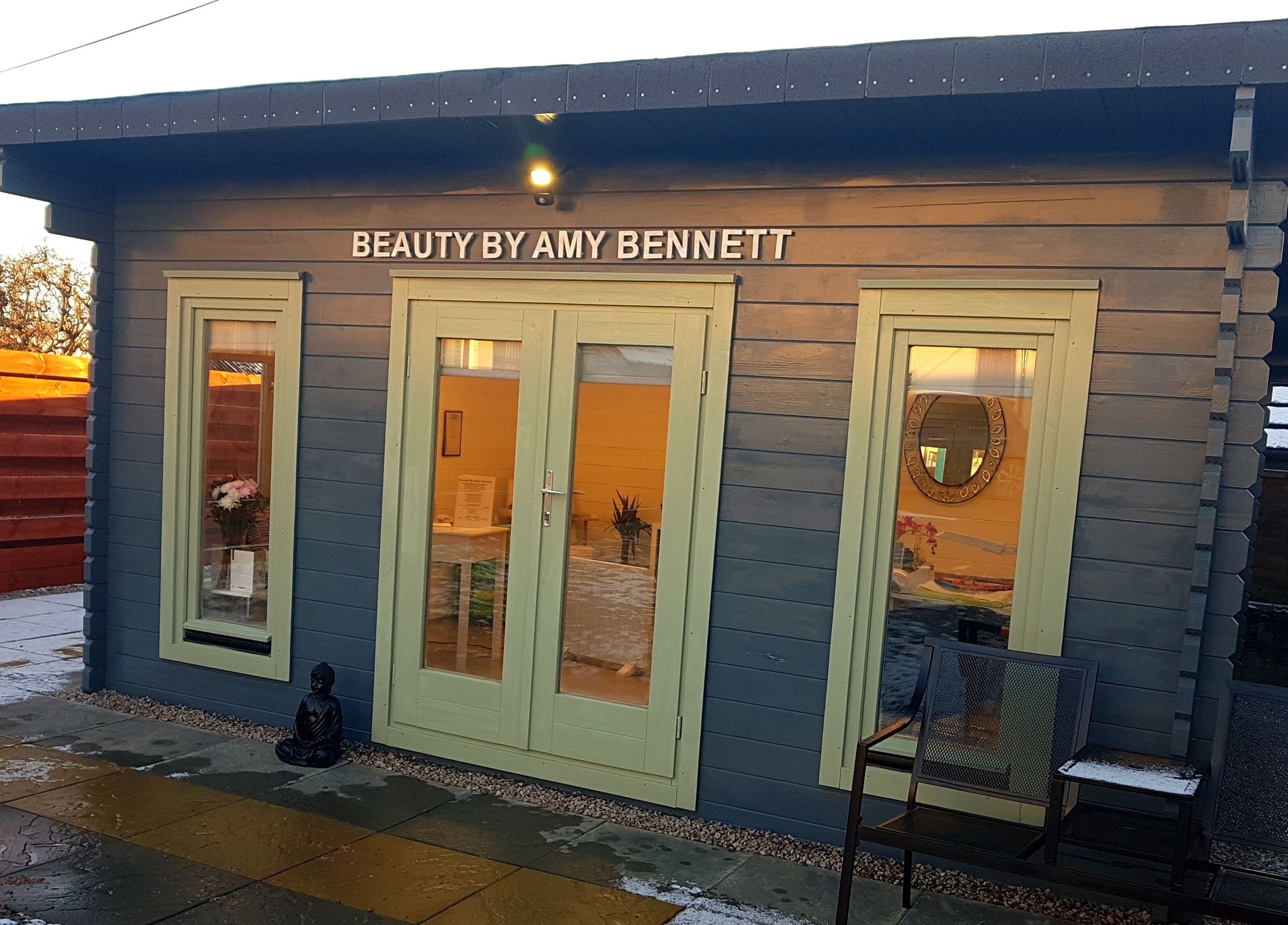 Beauty by Amy Bennett venue in Blackburn, Scotland, featuring a charming blue cabin with soft light.