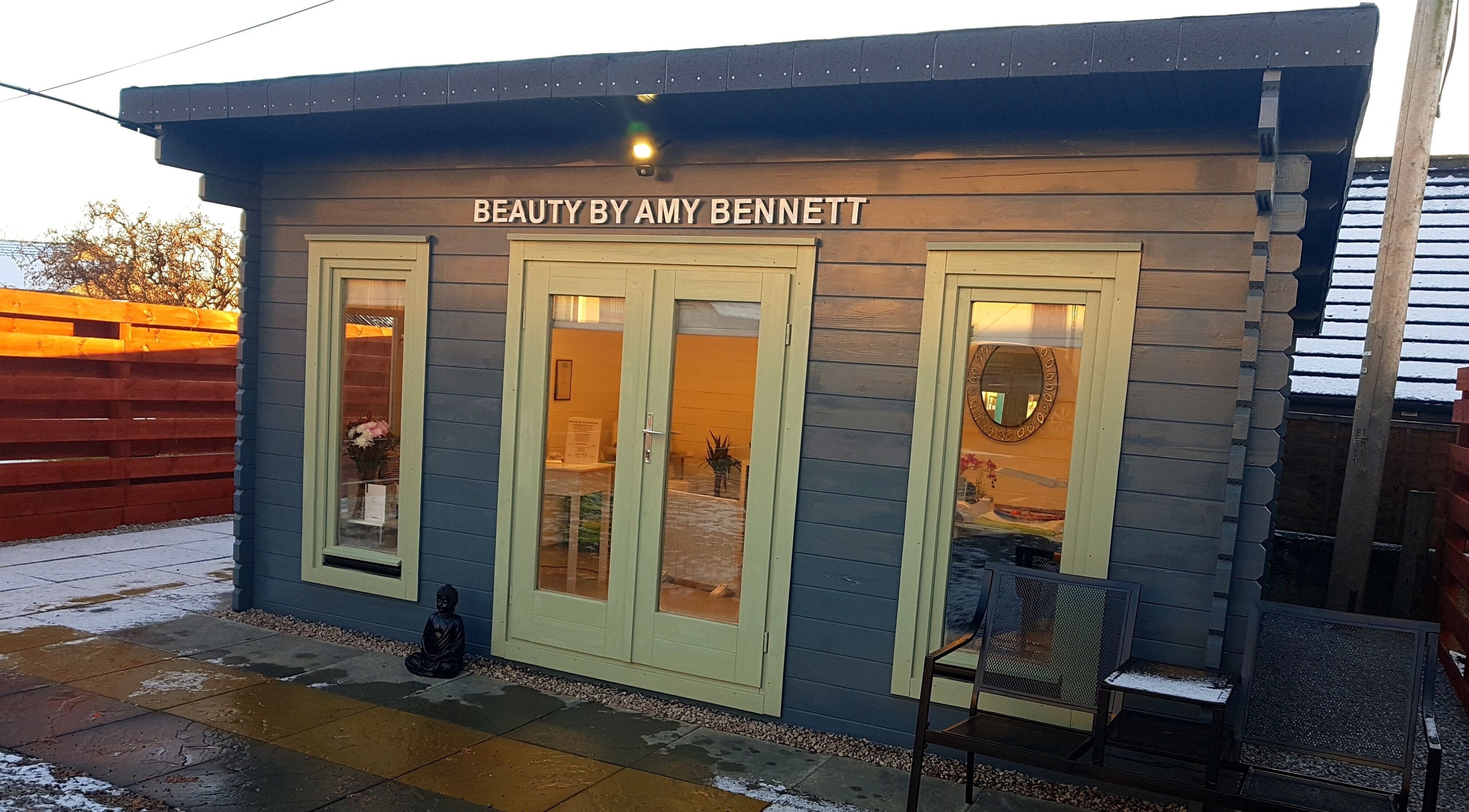 Beauty by Amy Bennett venue in Blackburn, Scotland, featuring a charming blue cabin with soft light.