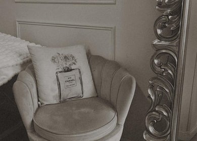 Cozy chair with designer cushion next to ornate mirror at Lash Society, Surry Hills, New South Wales, AU.