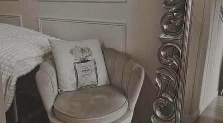 Cozy chair with designer cushion next to ornate mirror at Lash Society, Surry Hills, New South Wales, AU.
