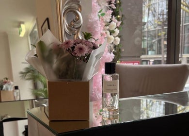 Elegant interior of Lash Society, Surry Hills, with flowers and perfume on a mirrored table.