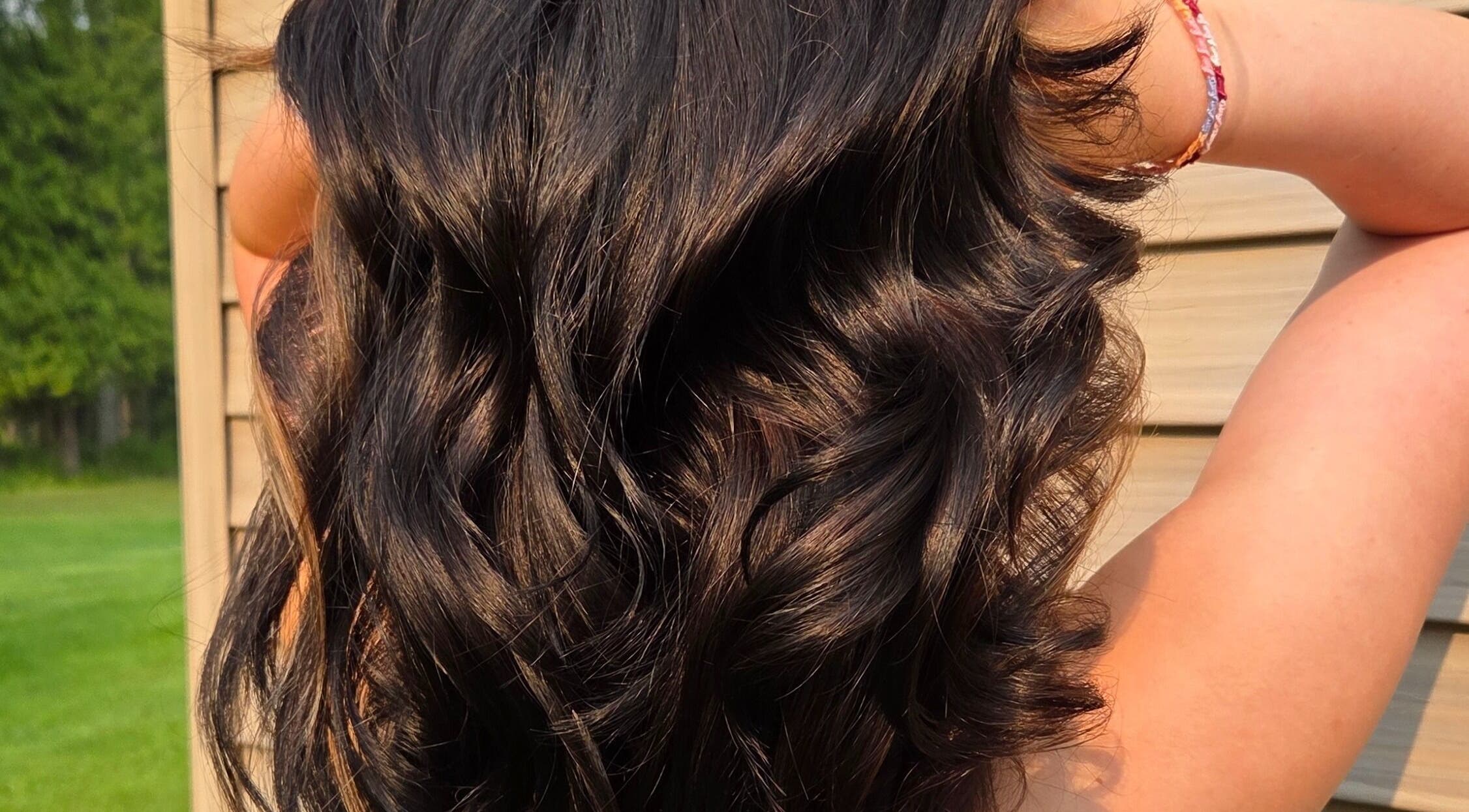 Glossy dark waves styled at Natalie Dyal, Green Bay, Wisconsin, US, capturing outdoor elegance.