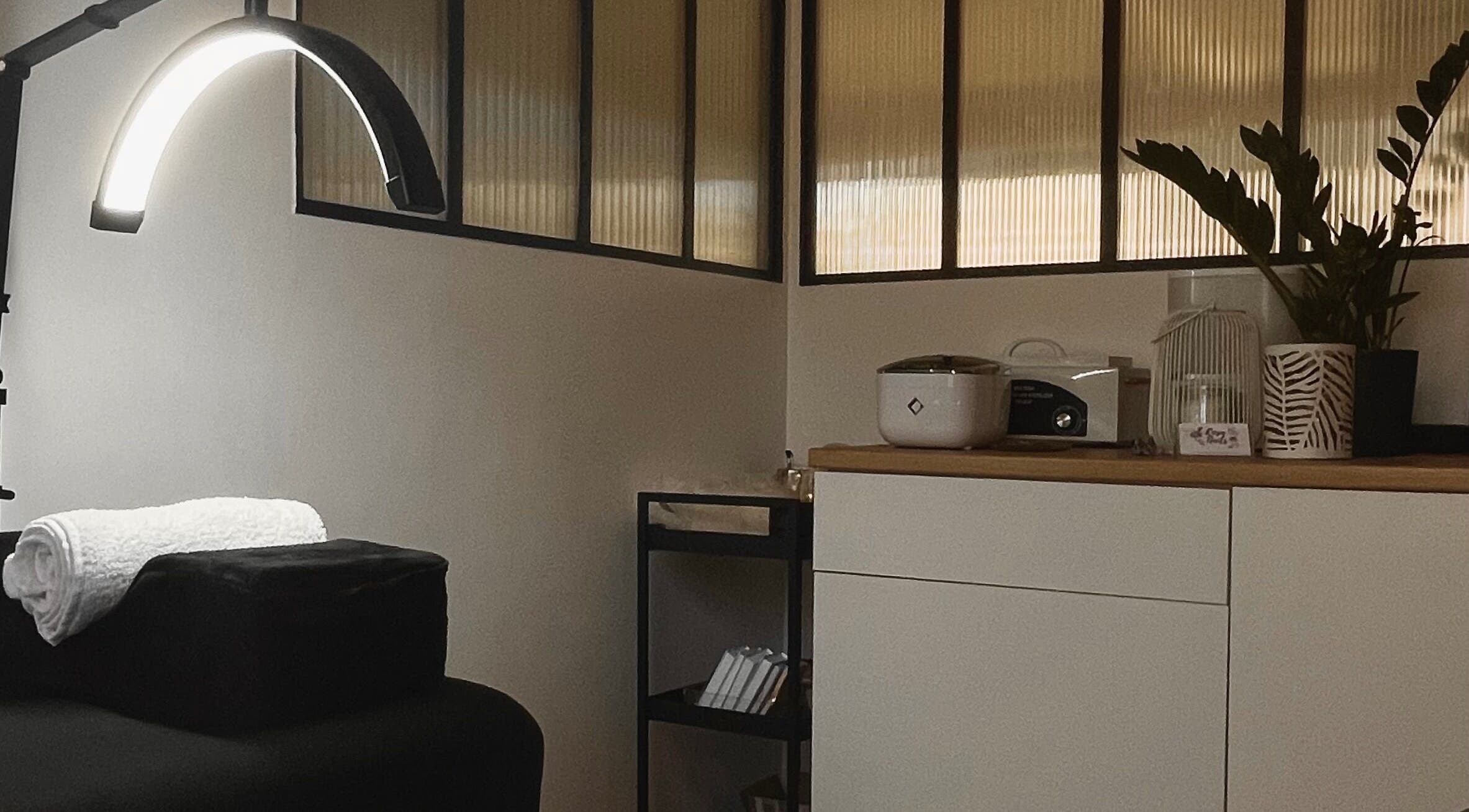 Salle de soins moderne à Beauty July, Bonnières-sur-seine, Île-de-france, FR, avec table de massage et décoration apaisante.