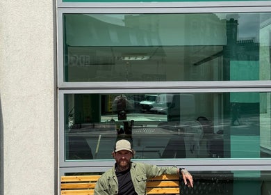 Exterior of Wakes Barbershop in Newquay, England, GB, showcasing its modern glass facade and iconic barber pole.