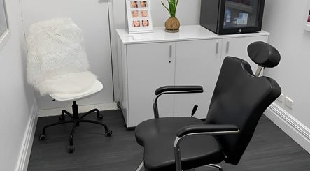 Modern treatment room at Smooth Skin Clinic, Esperance, Western Australia, AU, featuring sleek black chairs.