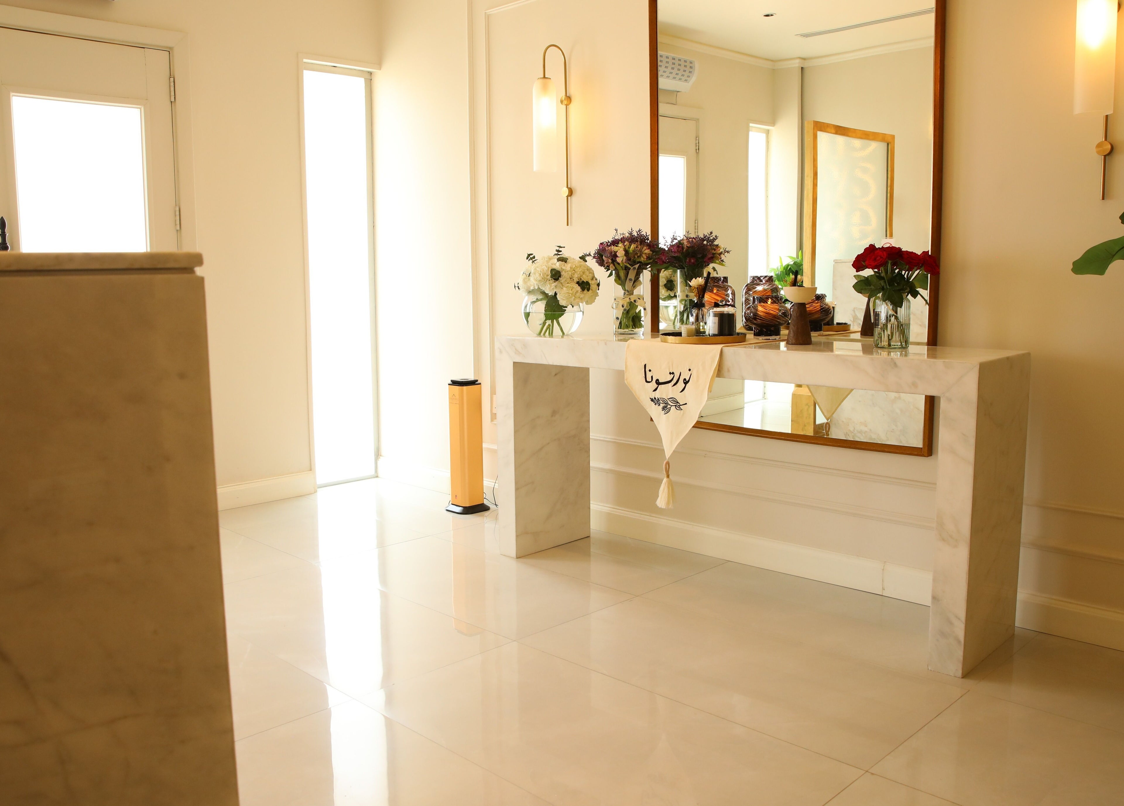 Chic entryway at The Brows Lounge, الرياض, منطقة الرياض, SA with a marble table and floral decor.