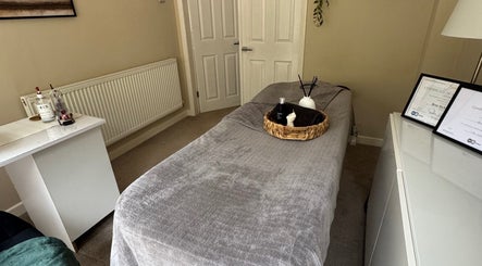 Tranquil treatment room at Eleventh Beauty, Malvern, England, GB, featuring cozy bed and soothing decor.