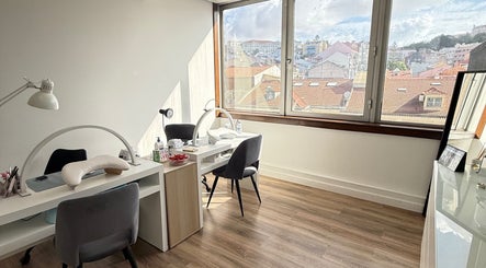 Interior moderno do VA Nails & Design, Lisboa. Mesa de manicure com vista panorâmica da cidade.