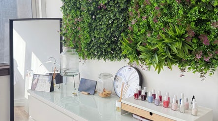 Interior da VA Nails & Design em Lisboa, PT, com decoração verde vibrante e produtos de beleza.