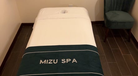 Massage bed in Mizu Spa Massage - Delray Beach, Florida, US with a plush chair.