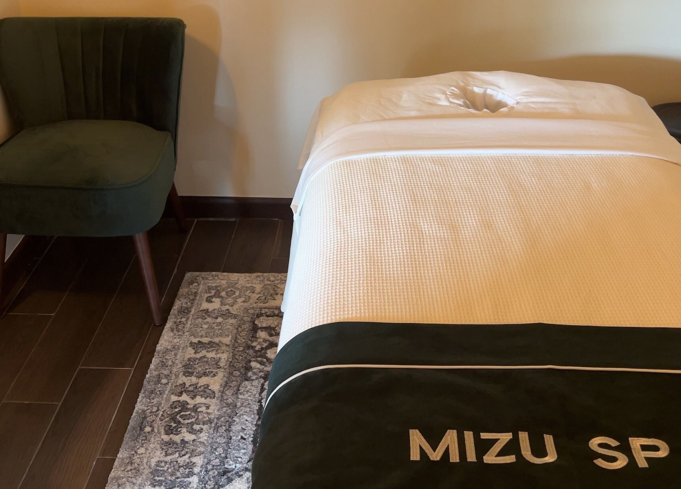 Relaxing massage room at Mizu Spa Massage - Delray Beach, Florida, US with a comfortable bed and chair.