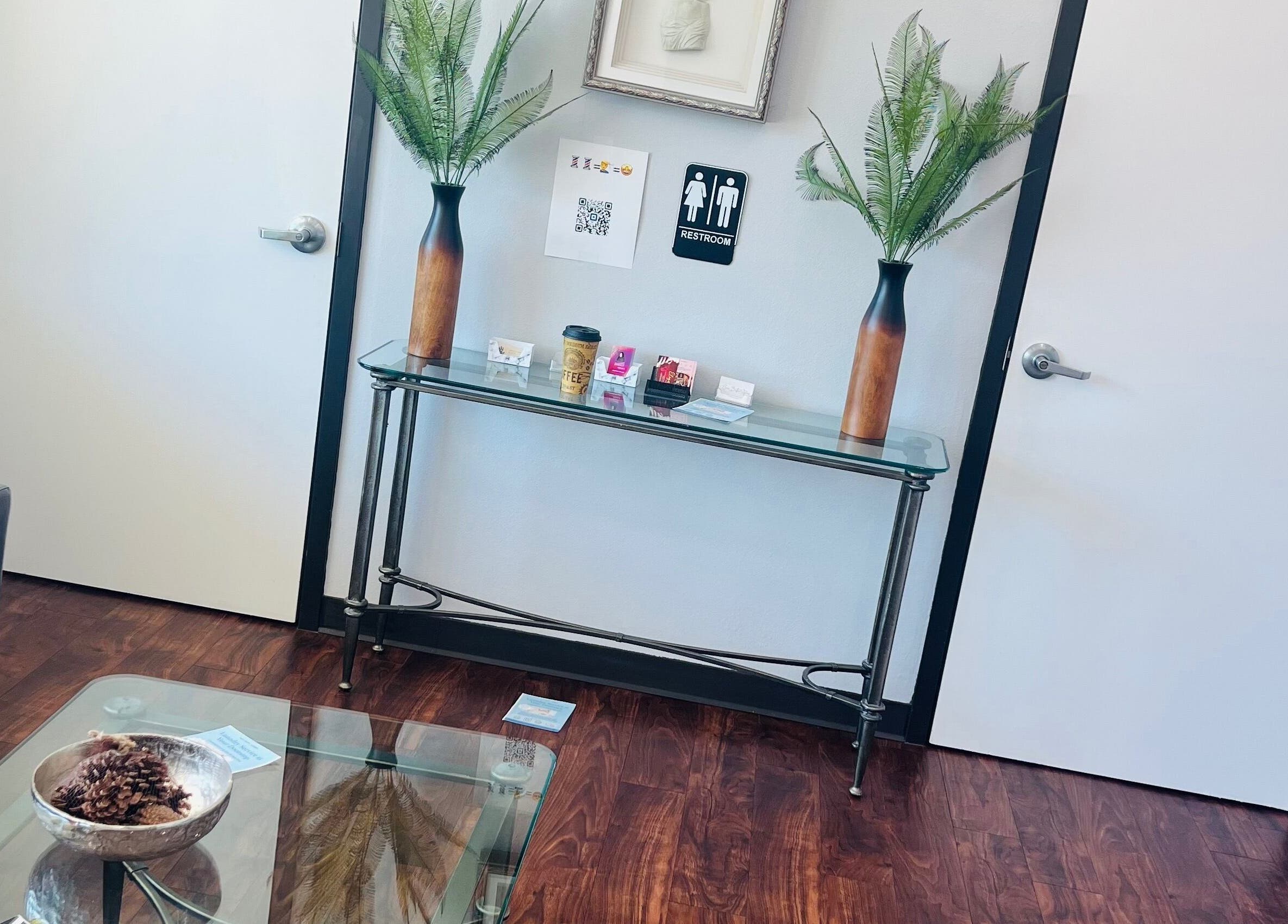 Elegant entryway at Key Hair Hands in Plano, Texas, US, featuring plants and a stylish glass console table.