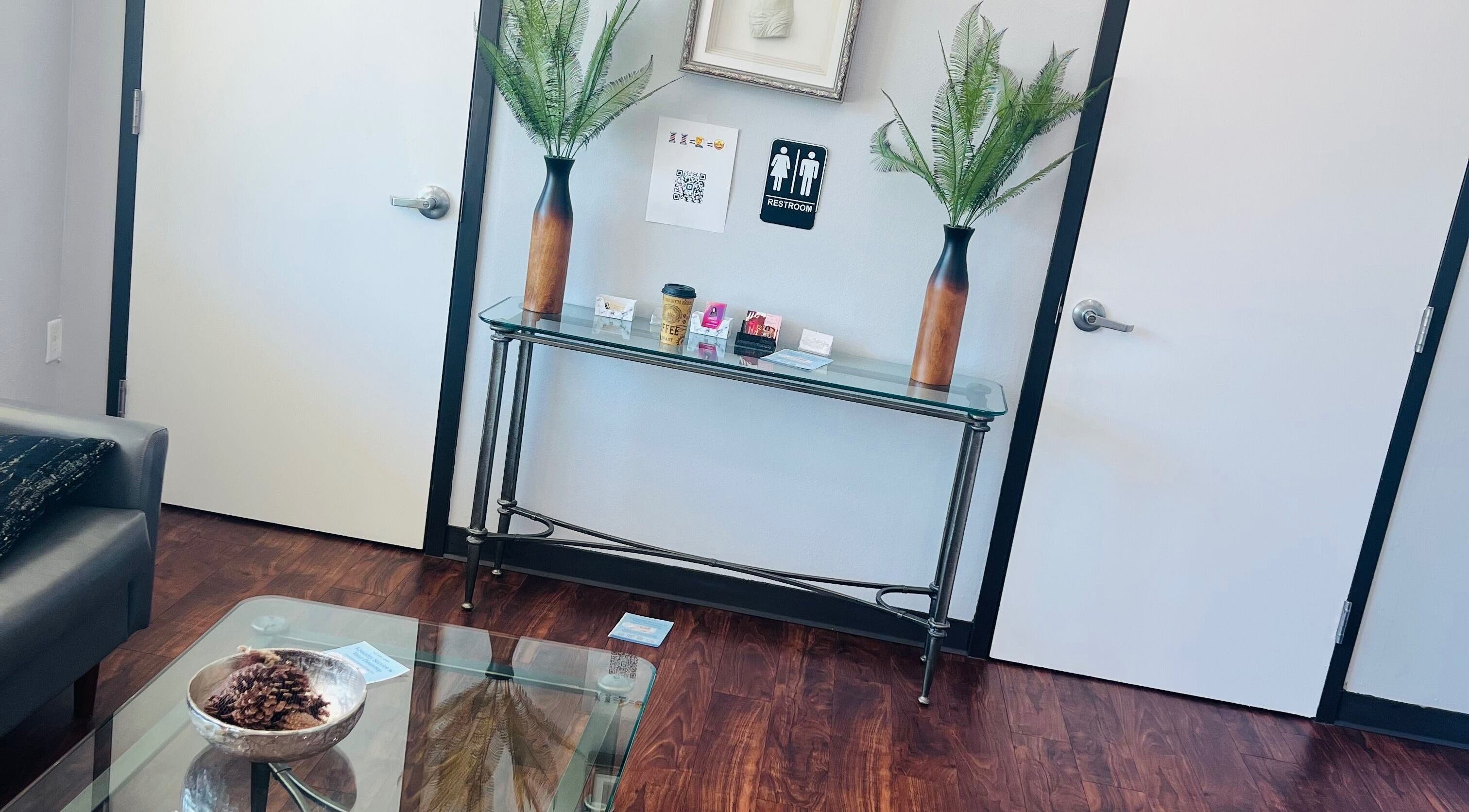 Elegant entryway at Key Hair Hands in Plano, Texas, US, featuring plants and a stylish glass console table.