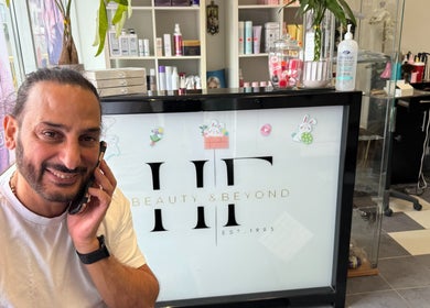 Person smiling at Hair Fashion 3000's inviting reception in Ajax, Ontario, CA, surrounded by beauty products.