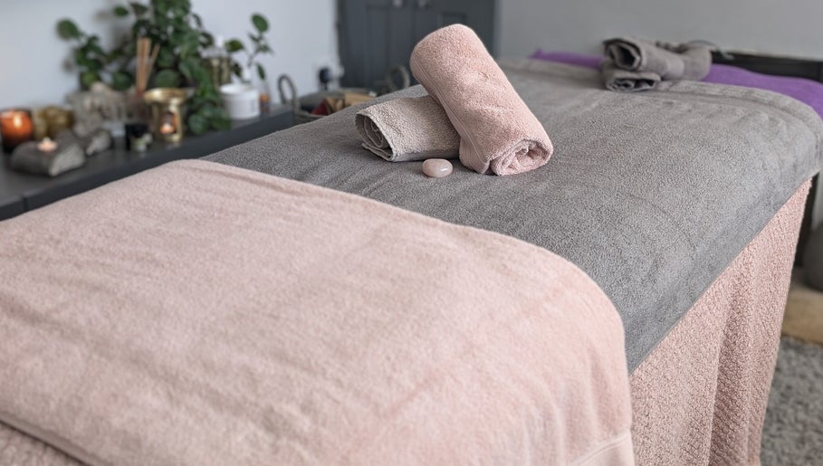 Massage table with rolled towels at Rekas holistic massage, Woking, England, GB, creating a serene space.