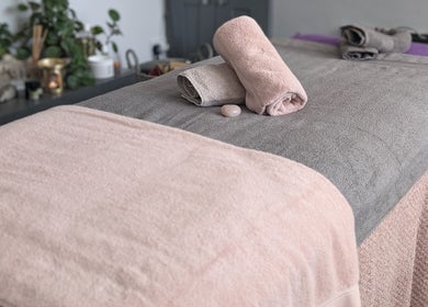 Massage table with rolled towels at Rekas holistic massage, Woking, England, GB, creating a serene space.