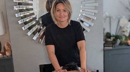 Therapist at Rekas holistic massage performing a massage in Woking, England, GB. Relaxing ambiance with mirror decor.