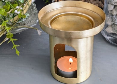 Golden candle holder with lit tealight at Rekas holistic massage, Woking, England, GB. Creates a calming ambiance.