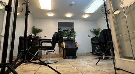 Cozy salon space at NO BRAND, Dublin, County Dublin, IE, featuring stylish chairs and greenery.