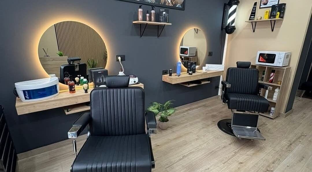 Interno di Barber Studio Mareci Francesco a Bagheria, Sicilia, con poltrone eleganti e specchi illuminati.