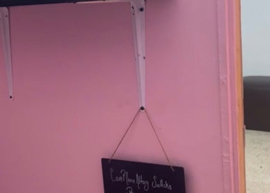 A stylish pink wall with a decorative sign at Luxlooks.bylea, Savanna La Mar, Westmoreland Parish, JM.