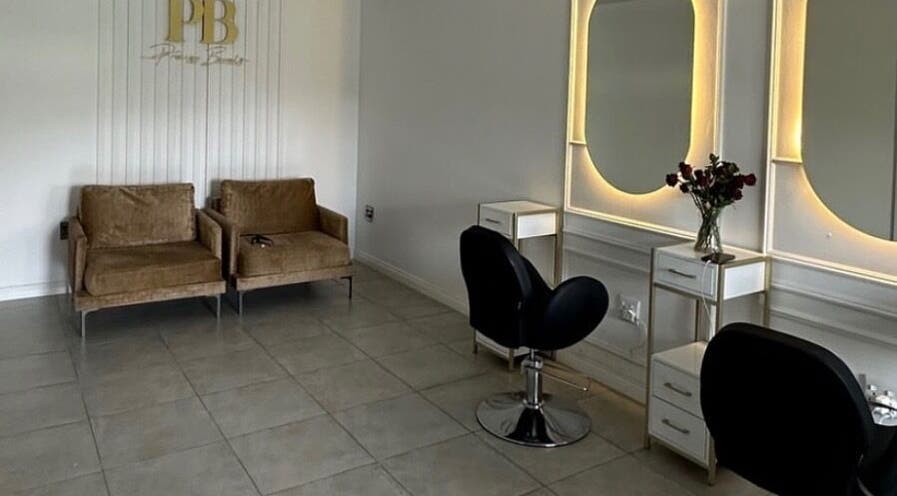Modern salon interior at Beauty by Ayo, Midrand, Gauteng, ZA featuring cozy seating and stylish mirrors.