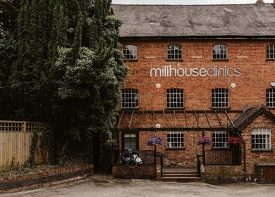 Get The Glo Wellness & Beauty at Millhouse Clinics in Alvechurch, England with historic brick facade.
