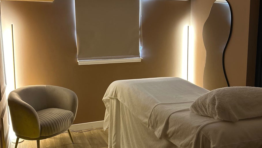 Calm treatment room at RS Skincare, Cumbernauld, Scotland, GB with a cozy chair and massage table.