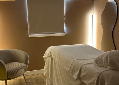 Calm treatment room at RS Skincare, Cumbernauld, Scotland, GB with a cozy chair and massage table.