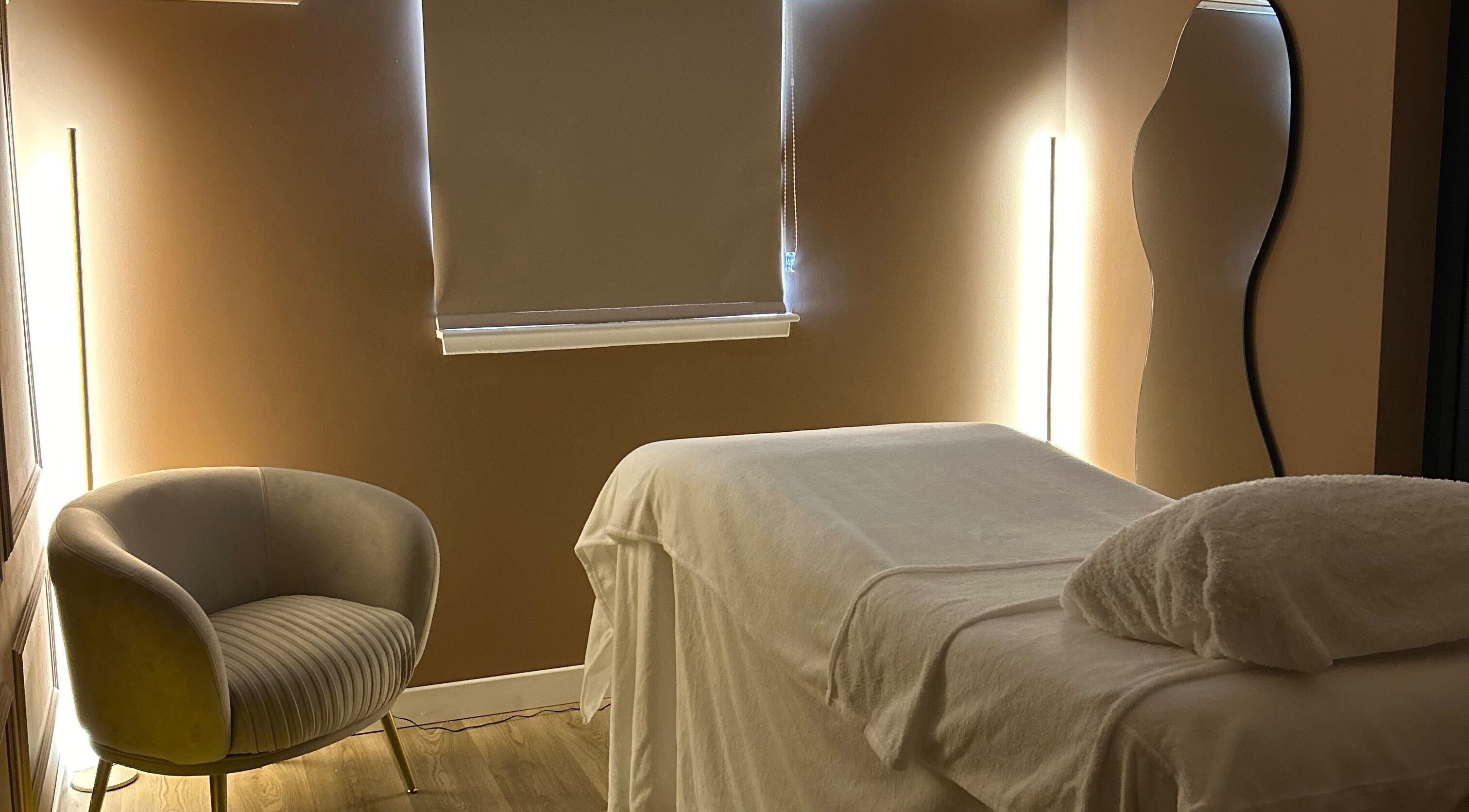 Calm treatment room at RS Skincare, Cumbernauld, Scotland, GB with a cozy chair and massage table.