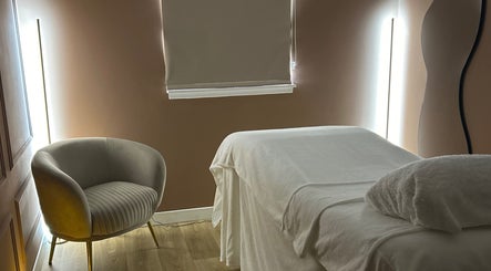 Relaxing treatment room at RS Skincare, Cumbernauld, Scotland, GB with cozy chair, bed, and soft lighting.
