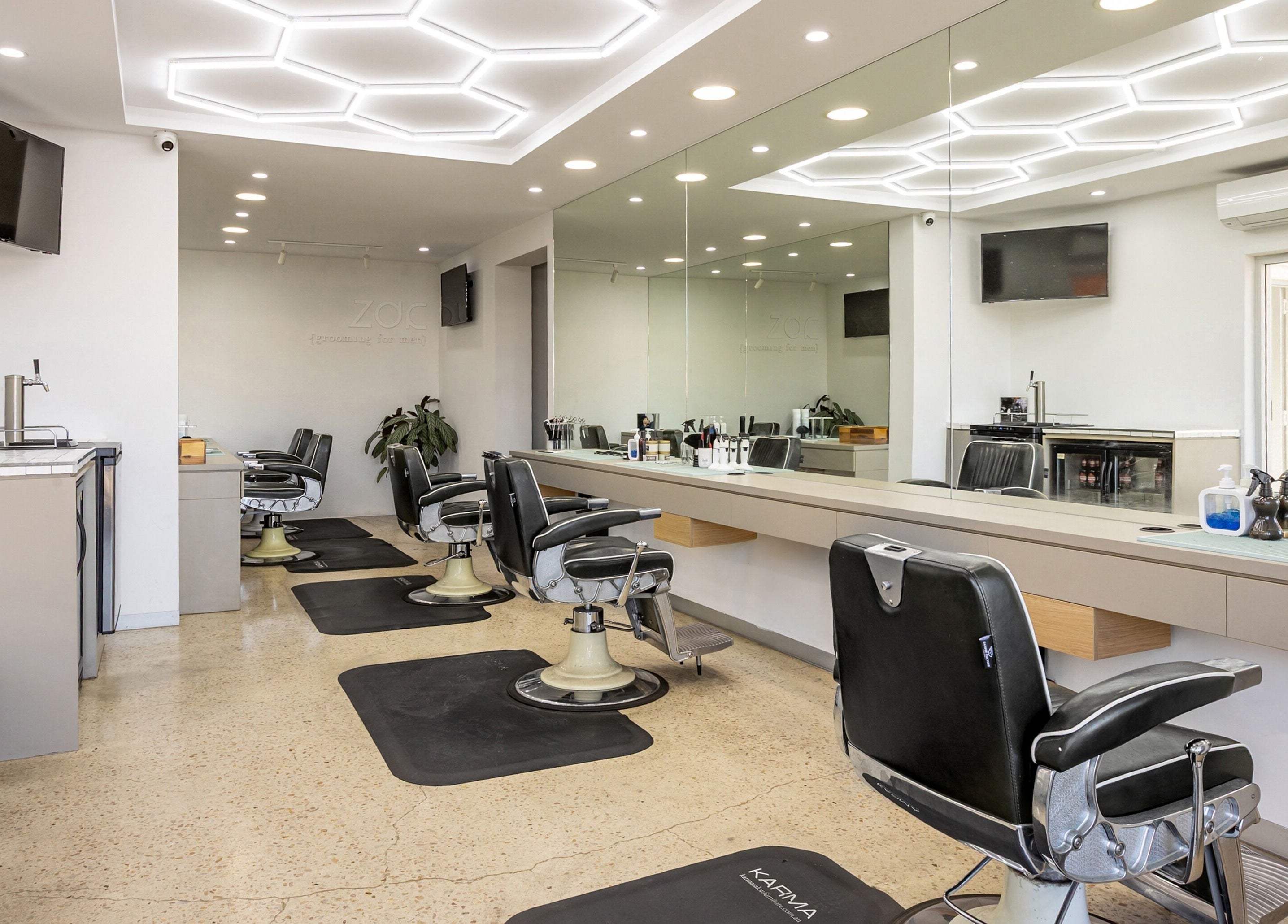 Modern interior of Zac Grooming for Men in Glenelg South, South Australia, AU with stylish barber chairs and mirrors.