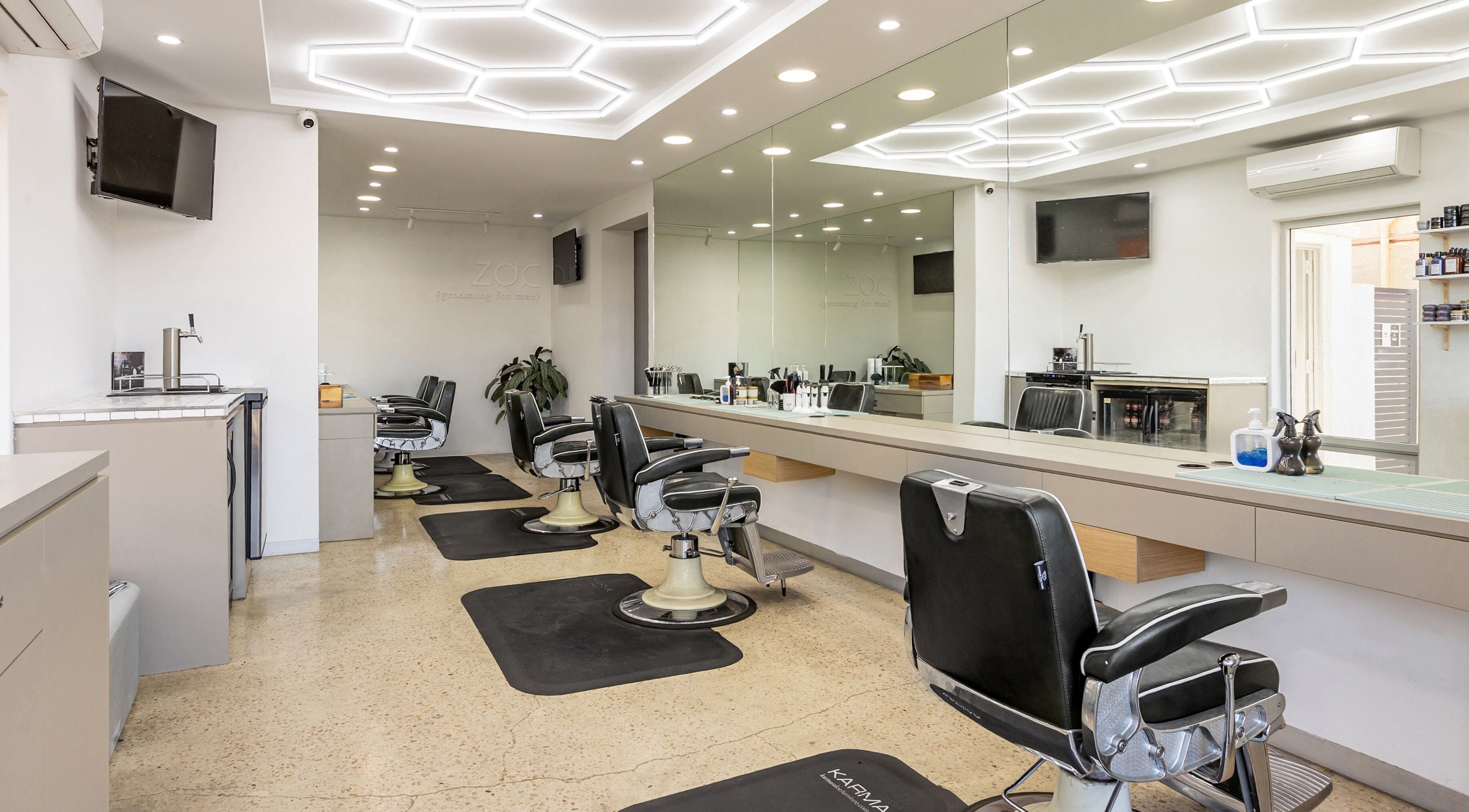 Modern interior of Zac Grooming for Men in Glenelg South, South Australia, AU with stylish barber chairs and mirrors.