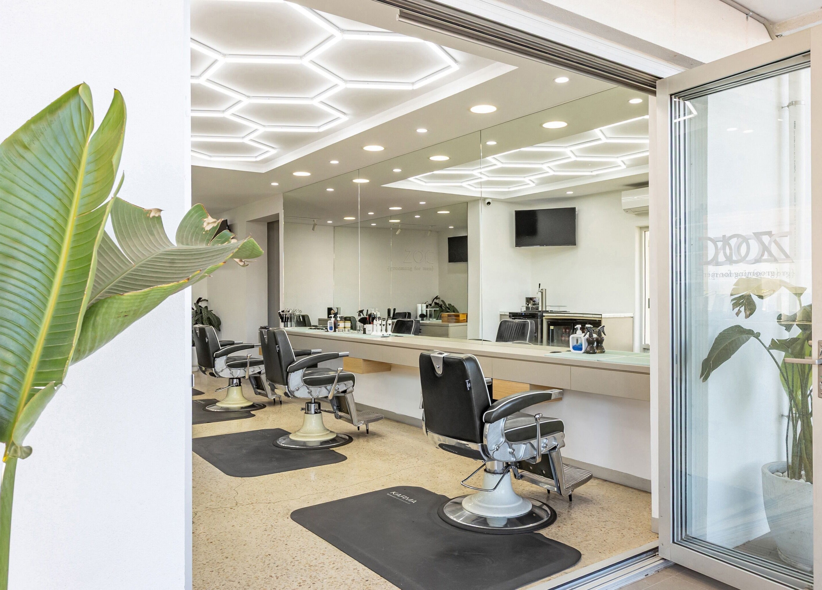 Chic interior of Zac Grooming for Men in Glenelg South, South Australia, showcasing modern barber chairs and mirrors.