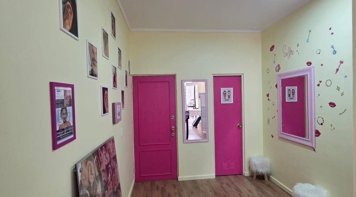 Interior del pasillo en Skar Piercing BodyArt con puertas rosa en Temuco, Araucanía, CL.