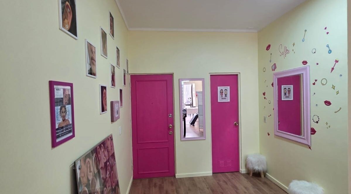 Interior del pasillo en Skar Piercing BodyArt con puertas rosa en Temuco, Araucanía, CL.