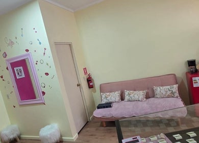 Zona de espera acogedora en Skar piercing bodyArt, Temuco, Araucanía, CL con sofá, espejos y decoración moderna.