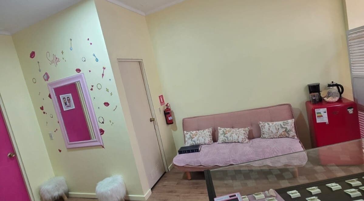 Zona de espera acogedora en Skar piercing bodyArt, Temuco, Araucanía, CL con sofá, espejos y decoración moderna.