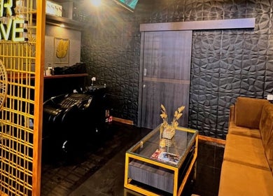 Chic interior of AFTERSHAVE BARBERSHOP in Bali, Bali, ID with stylish seating and textured walls.