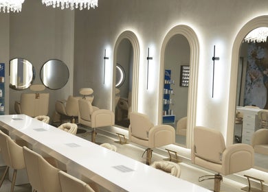 Luxurious interior of Crowns & Petals Beauty Salon in Dubai, AE showcasing bright mirrors and chic seating.