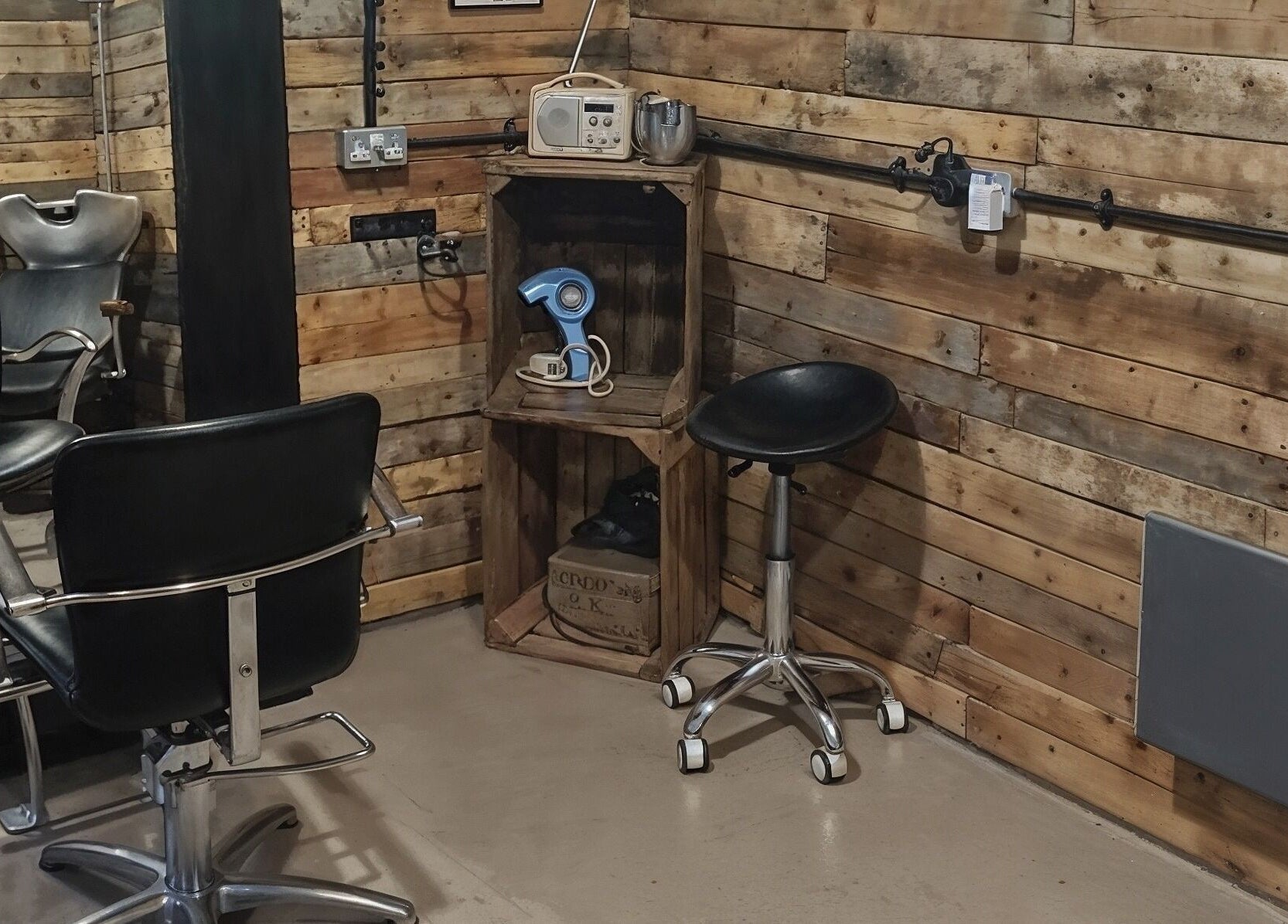 Chic rustic salon setup at The Cabin, Codicote, England, GB featuring wooden walls and stylish chairs.