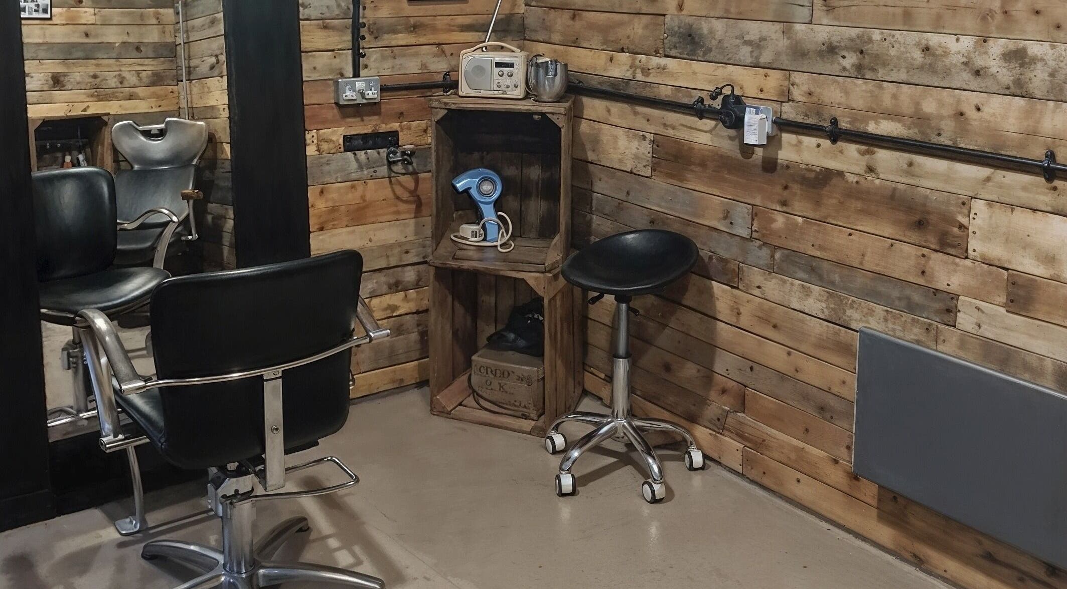 Chic rustic salon setup at The Cabin, Codicote, England, GB featuring wooden walls and stylish chairs.
