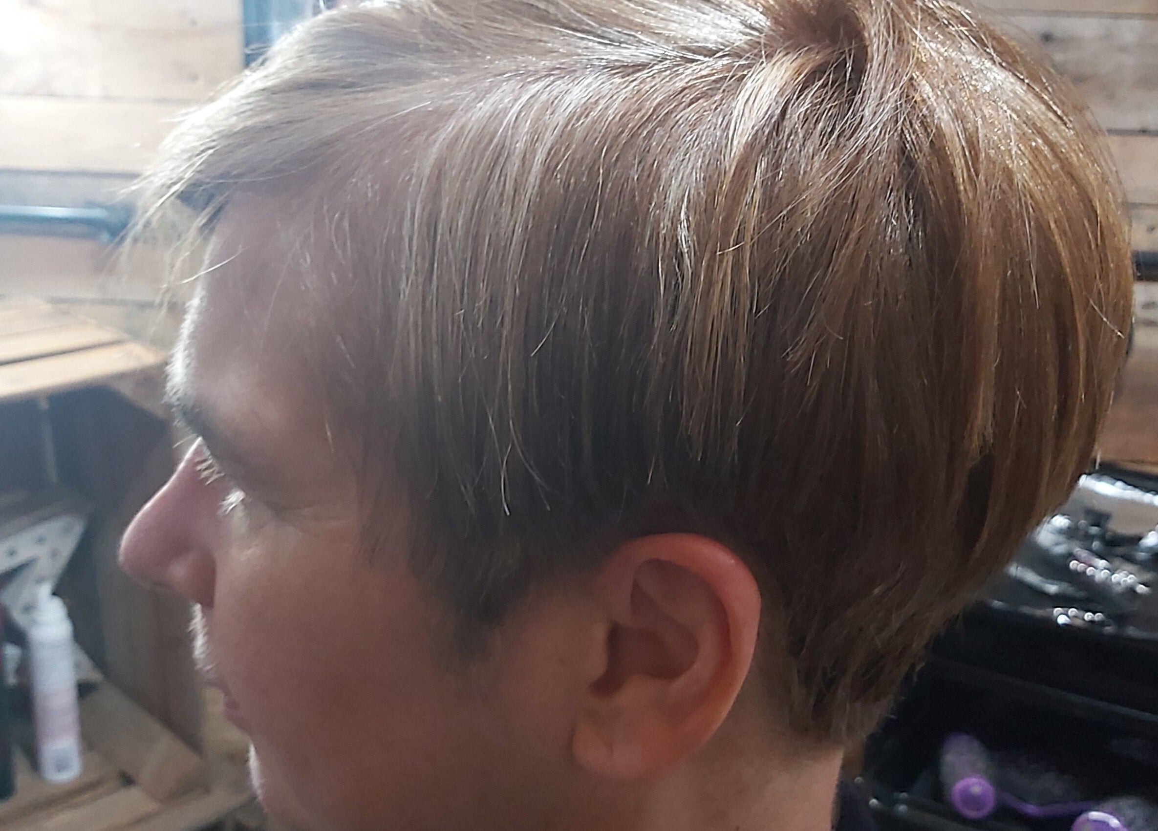 Side view of a stylish haircut at The Cabin, Codicote, England, GB showcasing glossy, well-groomed hair.