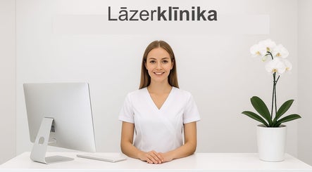 Receptionist at Lāzer Klīnika Domina, Rīga, LV, welcomes clients warmly in a modern setting.